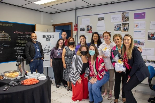 10 pessoas de máscara posam para a foto com em sala de aula com referências ao projeto Programa Jornada Horizontes do Empreendedor