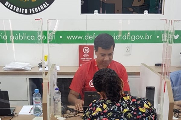 Fotografia de um homem atendendo uma mulher no mutirão da Defensoria Pública do DF