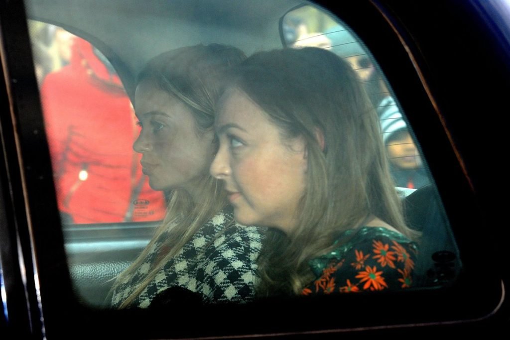 Foto colorida de duas mulheres brancas sentadas no banco de trás de um carro - Metrópoless