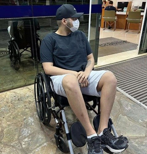 Jovem sentado em cadeira de rodas