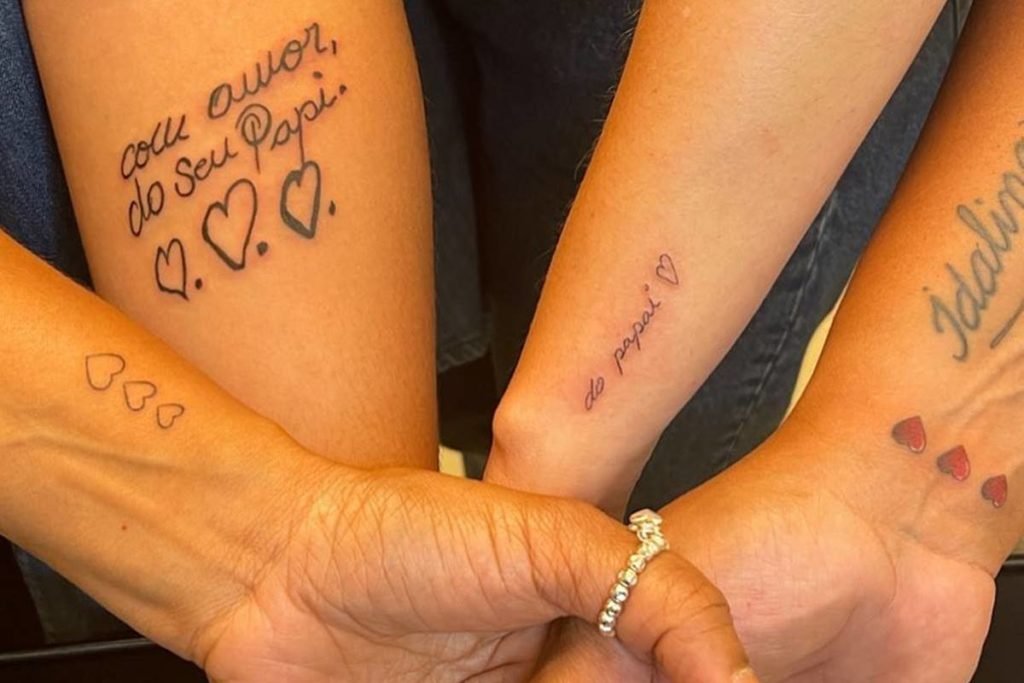 Filhas de Pelé com os braços juntos. As irmãs mostram homenagem feita tatuando frases do pai, morto no final do ano passado - Metrópoles