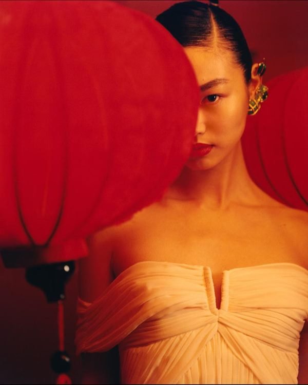 Mulher asiática em editorial de moda. Ela está usando vestido branco e joias na orelha - Metrópoes