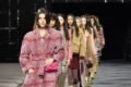 Fila de modelos mulheres e jovem no final do desfile da marca francesa Chanel. Ela usam roupas da marca. No fundo, é possível ver um painel de tecido quadriculado com a logo da marca. - Metrópoles