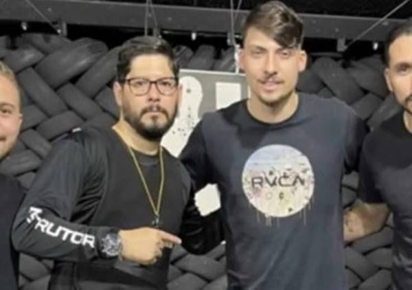 Jair Renan, filho do ex-presidente Bolsonaro, e Maciel Carvalho, empresário do rapaz que foi preso por fraude em compra de armas. Eles aparecem em estande de tiros, abraçados e sorrindo para a foto - Metrópoles