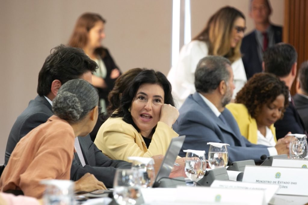 O presidente Lula faz primeira reunião ministerial no Palácio do Planalto e pede boa relação com o Congresso Nacional. Na imagem Simone Tebet e Marina Silva conversam sentadas à mesa- Metrópoles