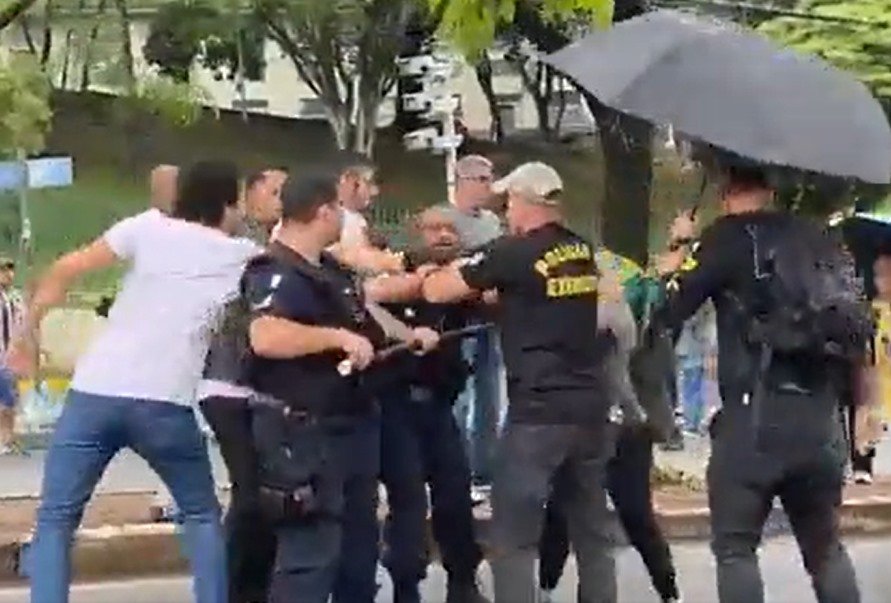 Jornalistas da Band são agredidos por militantes bolsonaristas e tem cozinhas quebradas em Belo Horizonte.  Na imagem, eles são cercados por vários homens - Metrópoles