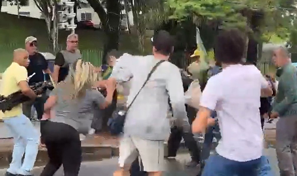 Jornalistas da Band são agredidos por militantes bolsonaristas e tem cozinhas quebradas em Belo Horizonte.  Na imagem, eles são cercados por vários homens - Metrópoles