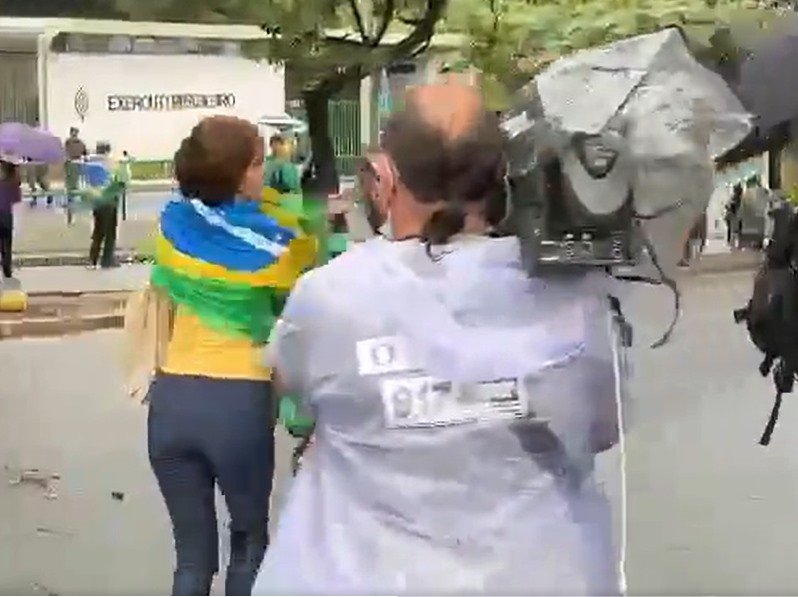 Jornalistas da Band são agredidos por militantes bolsonaristas e tem cozinhas quebradas em Belo Horizonte.  Na imagem, eles são cercados por vários homens - Metrópoles