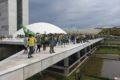 Imagem colorida de bolsonaristas em cima do Congresso Nacional