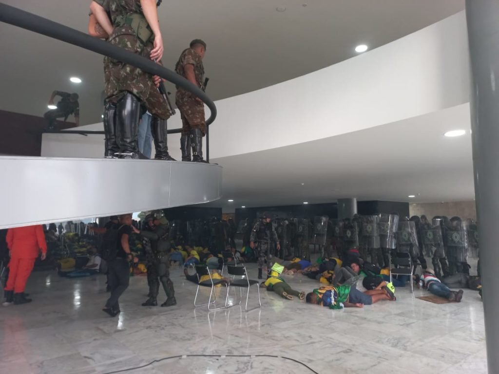 Manifestantes bolsonaristas presos no Palácio do Planalto durante protestos antidemocráticos na Esplanada dos Ministérios. Agentes da força de segurança mantem dezenas de terroristas algemados no chão do prédio - Metrópoles