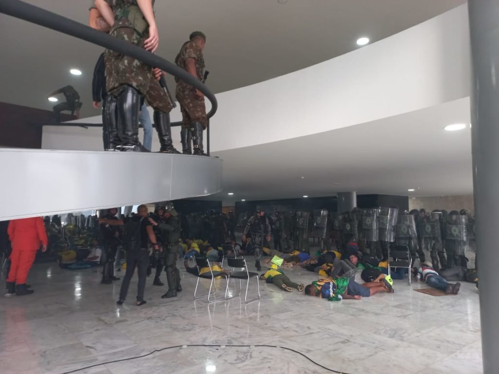 Manifestantes bolsonaristas presos no Palácio do Planalto durante protestos antidemocráticos na Esplanada dos Ministérios. Agentes da força de segurança mantem dezenas de terroristas algemados no chão do prédio - Metrópoles