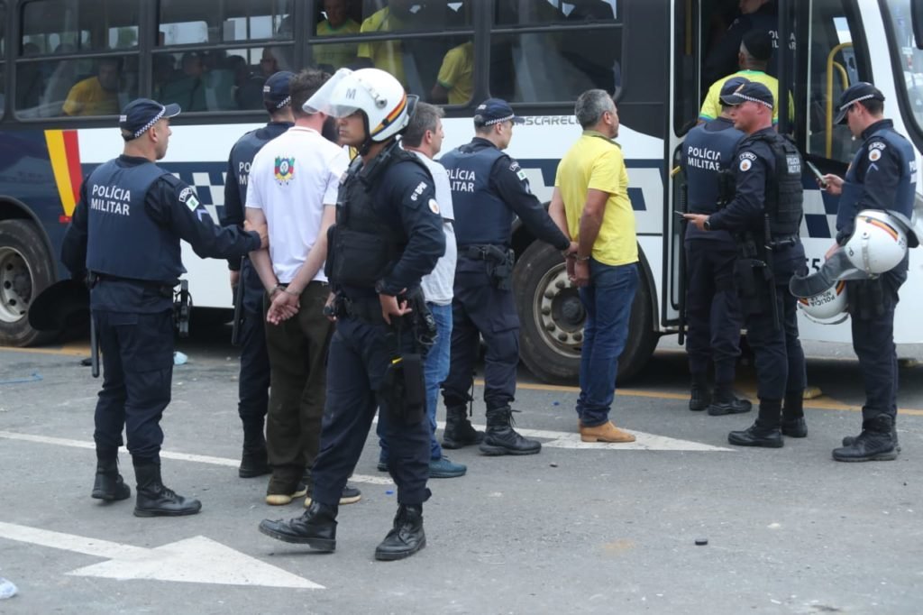 Manifestantes bolsonaristas presos no Palácio do Planalto durante protestos antidemocráticos na Esplanada dos Ministérios. Agentes das forças de segurança levam homens algemados para dentro de ônibus da PMDF - Metrópoles
