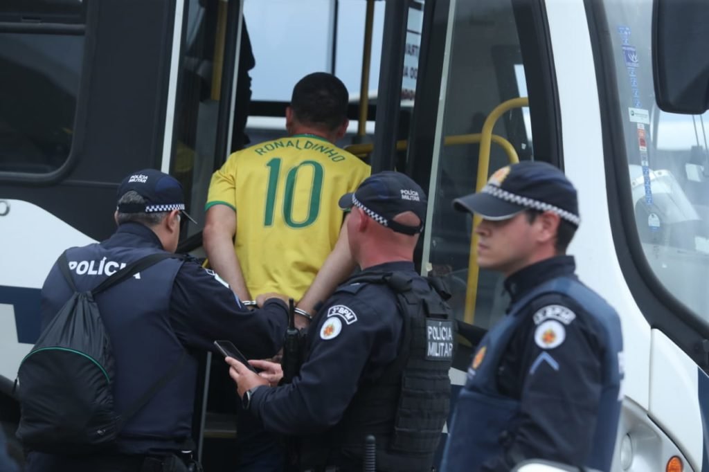 Manifestantes bolsonaristas presos no Palácio do Planalto durante protestos antidemocráticos na Esplanada dos Ministérios. Agentes das forças de segurança levam homens algemados para dentro de ônibus da PMDF após ataques - Metrópoles