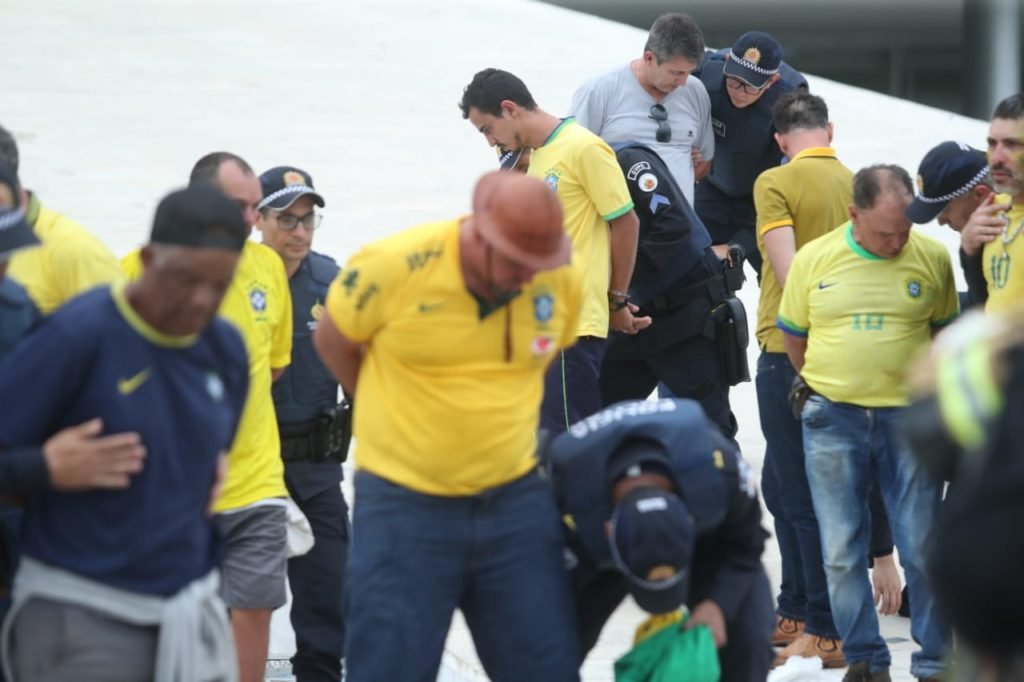 Manifestantes bolsonaristas presos no Palácio do Planalto durante protestos antidemocráticos na Esplanada dos Ministérios. Agentes das forças de segurança levam homens algemados para dentro de ônibus da PMDF - Metrópoles
