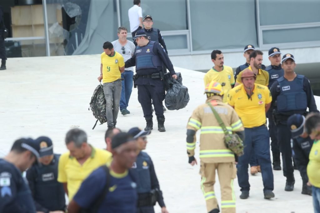 Manifestantes bolsonaristas presos no Palácio do Planalto durante protestos antidemocráticos na Esplanada dos Ministérios. Agentes das forças de segurança levam homens algemados para dentro de ônibus da PMDF - Metrópoles