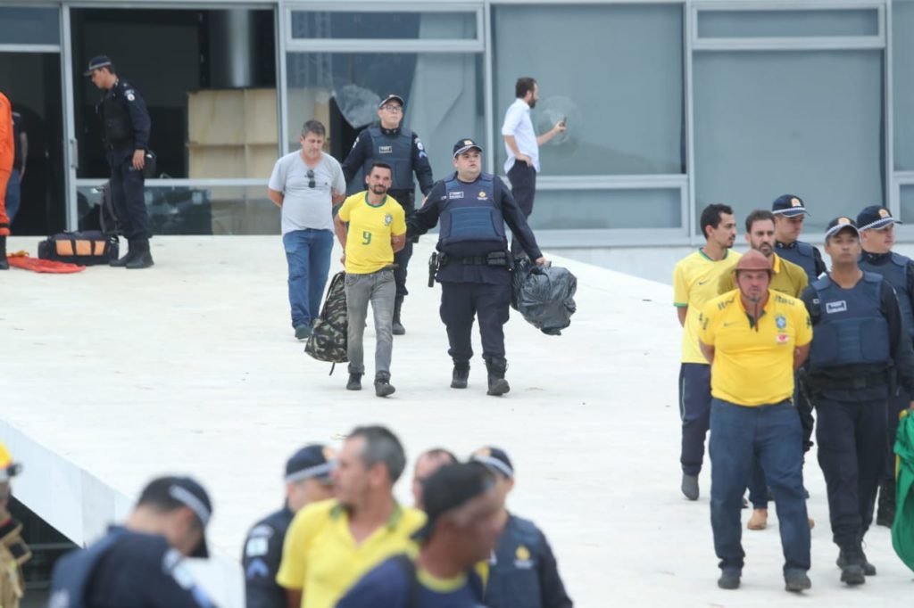 Manifestantes bolsonaristas presos no Palácio do Planalto durante protestos antidemocráticos na Esplanada dos Ministérios. Agentes das forças de segurança levam homens algemados para dentro de ônibus da PMDF - Metrópoles