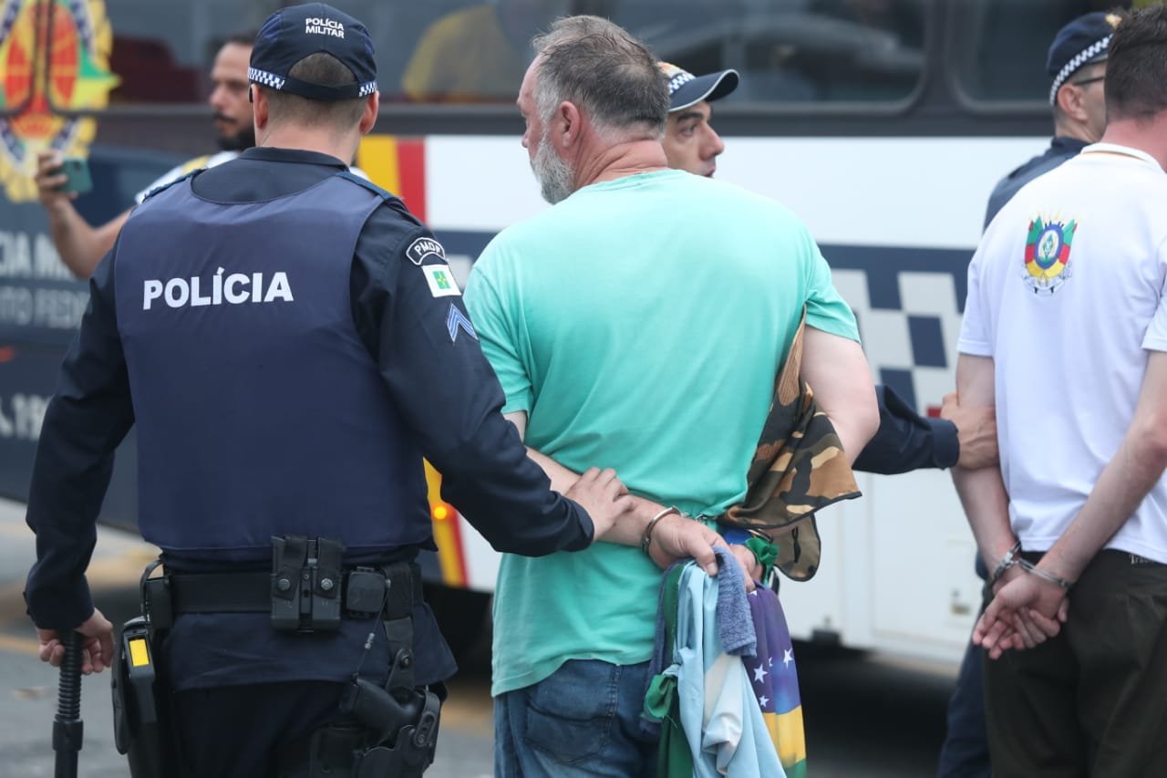 Manifestantes bolsonaristas presos no Palácio do Planalto durante protestos antidemocráticos na Esplanada dos Ministérios. Agentes das forças de segurança levam homens algemados para dentro de ônibus da PMDF - Metrópoles