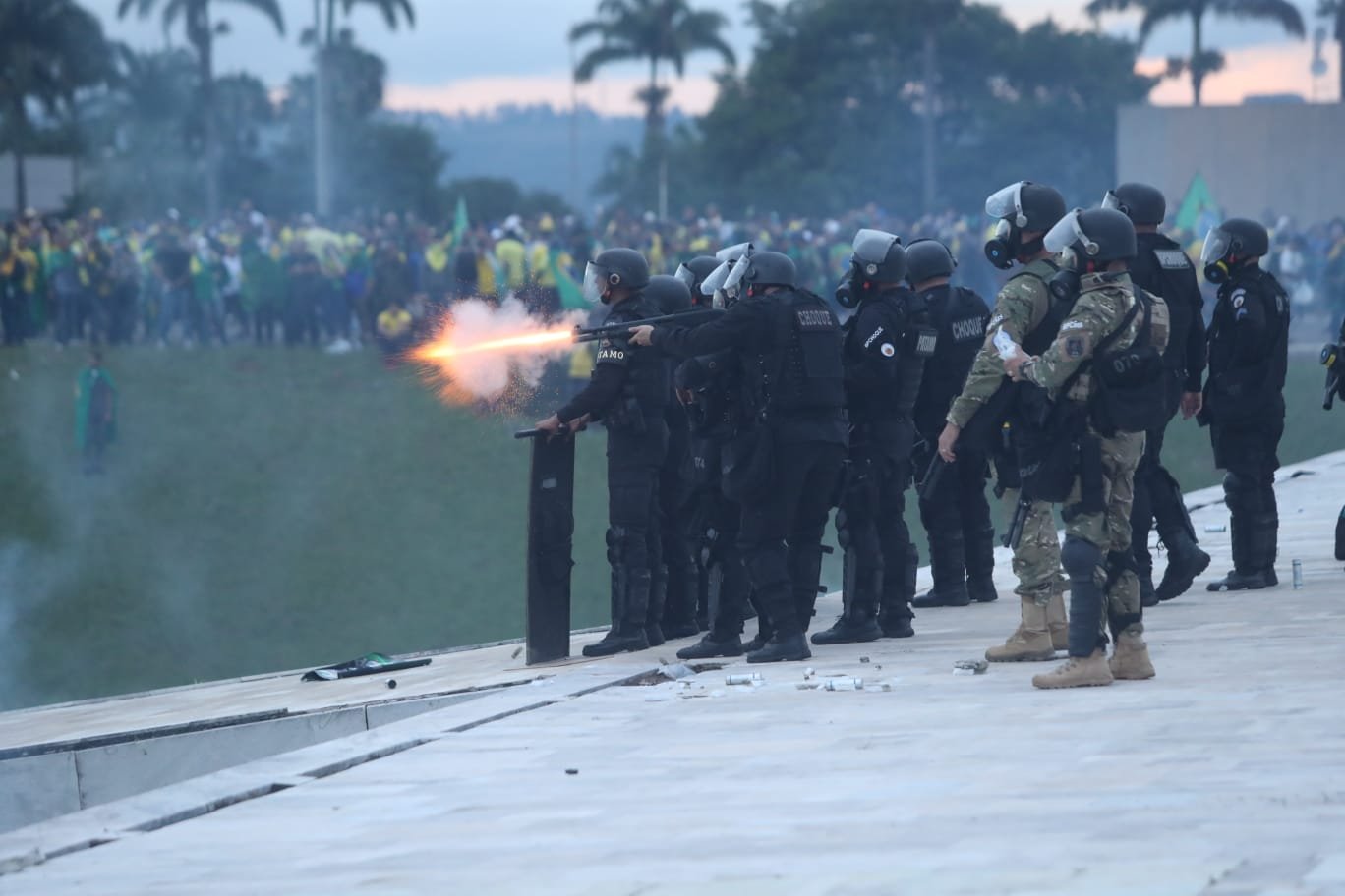 Tropa de Choque da PMDF durante retirada de manifestantes bolsonaristas do Congresso Nacional após invasão. Agentes atiram com balas de borracha na parte de cima do prédio - Metrópoles