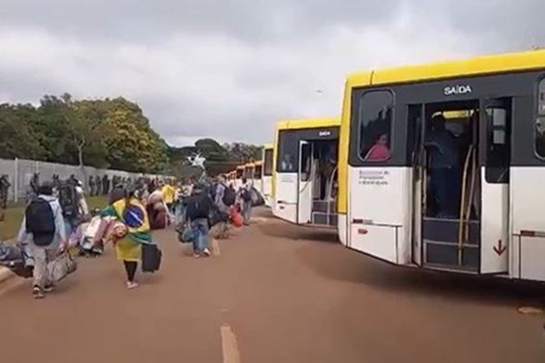 Imagem colorida de pessoas embarcando em ônibus