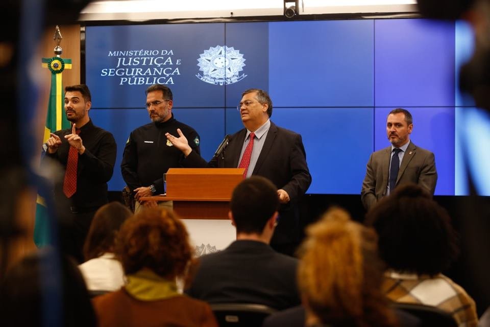 Ministro da Justiça, Flávio Dino, concede entrevista coletiva no Palácio da Justiça sobre a invasão e depredação dos prédios dos Três Poderes. Ele aparece ladeado por duas autoridades policiais - Metrópoles