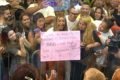 brunna gonçalves segura cartaz rosa em meio a multidão na frente da casa de vidro do bbb23 - metrópoles
