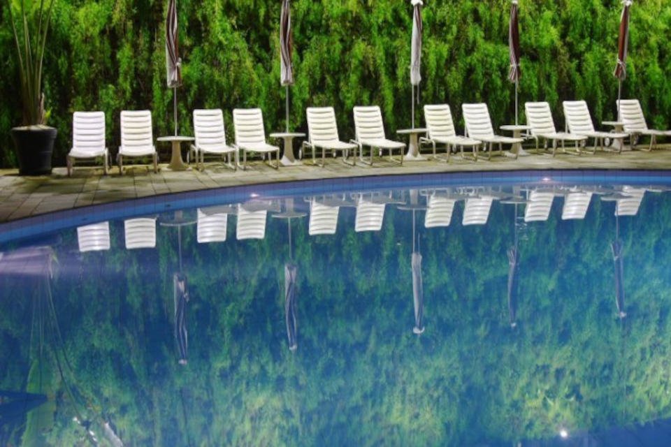 piscina com cadeiras na margem