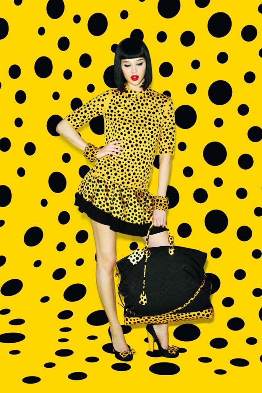 Foto de campanha publicitária da marca Louis Vuitton. A coleção de roupas e acessórios foi feita em parceria com a artista Yayoi Kusama. A modelo, branca e jovem, de cabelo curto chanel preto, usa um vestido amarelo com bolinhas pretas e uma bolsa preta com bolinhas amarelas. - Metrópoles