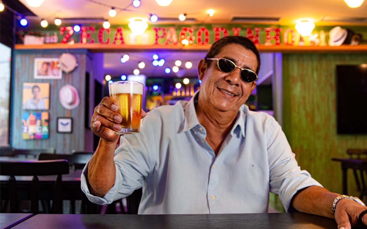O cantor Zeca Pagodinho em uma mesa do Bar do Zeca Pagodinho