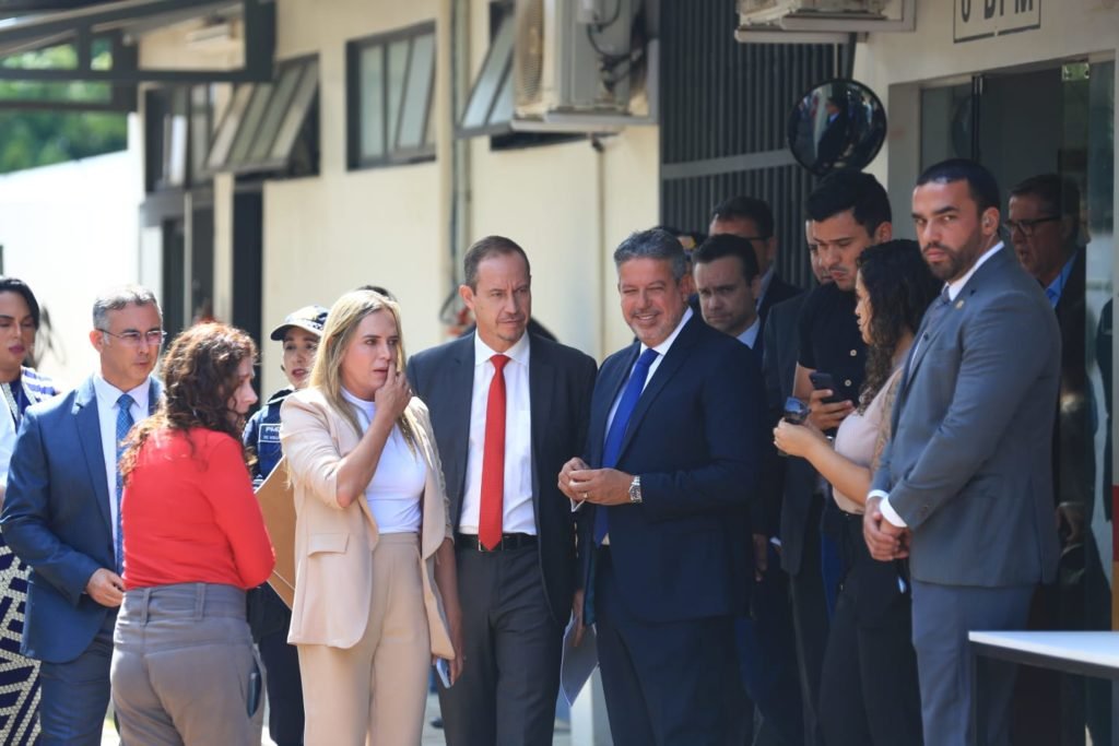 A governadora em exercício, Celina Leão; o interventor, Ricardo Cappelli e o presidente da Câmara dos Deputados, Arthur Lira falam com a imprensa após visita e anúncio de reformas no 6⁰ Batalhão da PM, próximo à Esplanada. No detalhe, os três aparecem rodeados por autoridades na saída do local - Metrópoles