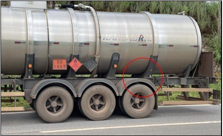 lateral de caminhão com círculo vermelho perto de roda traseira