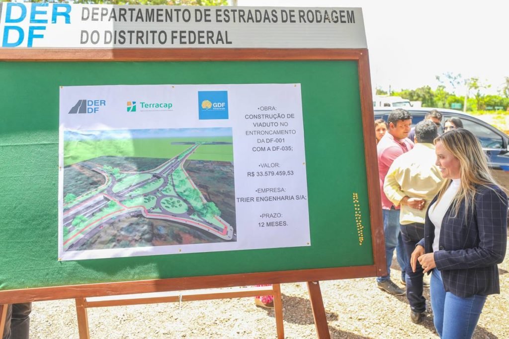 Foto de uma mulher à direita em frente a um painel verde