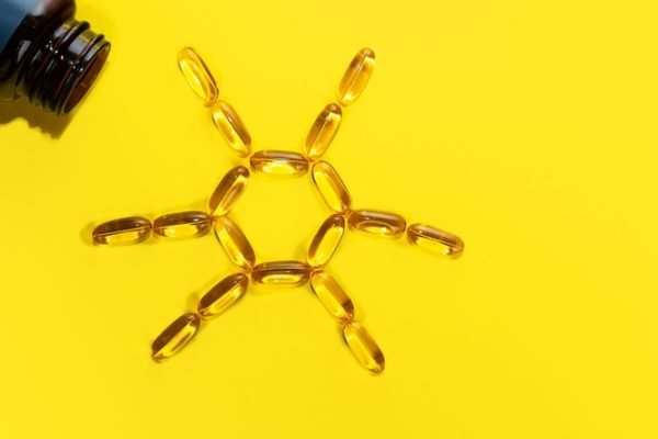 Imagem colorida: capsulas de vitamina D formam desenho de sol - Metrópoles