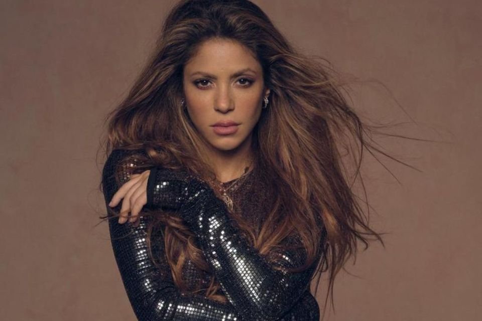 Cantora Shakira com blusa preta e braços cruzados - Metrópoles