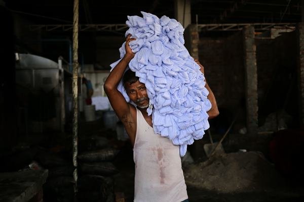 Homem trabalhando em confecção têxtil - Metrópoles