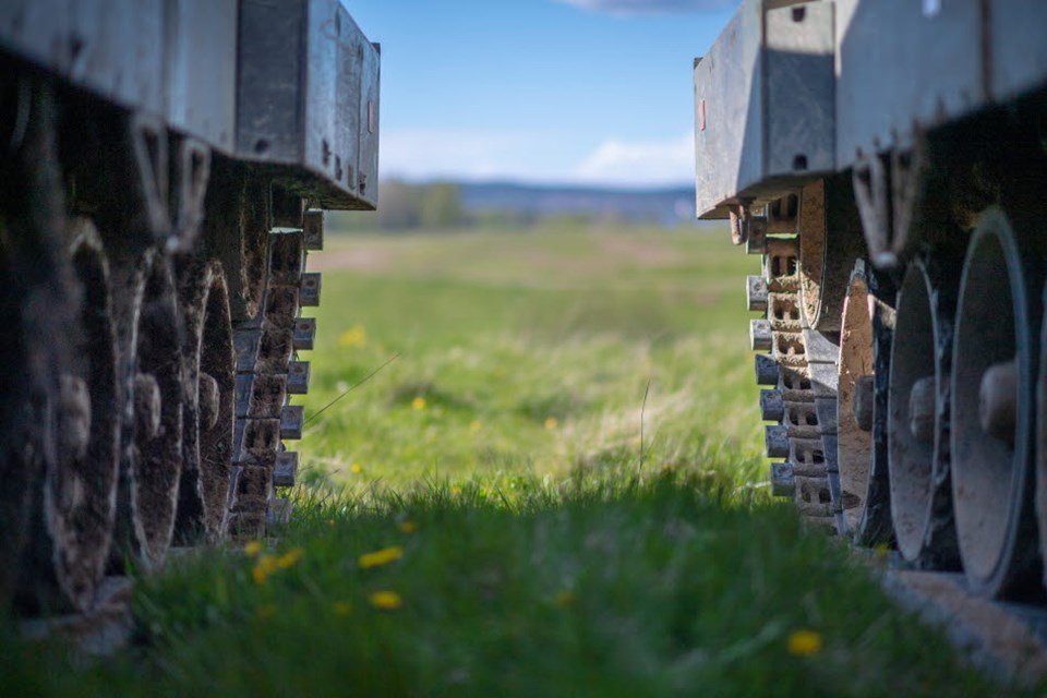 Foto colorida de dois tanques de guerra em um campo verde - Metrópoles