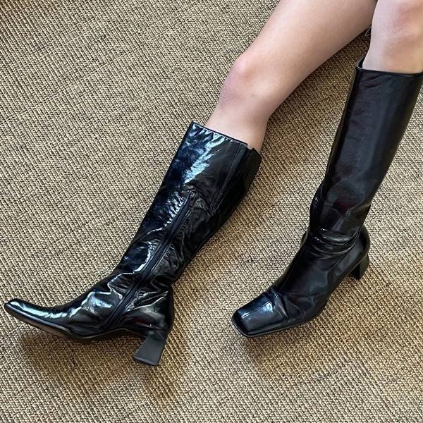 Modelo usa botas pretas de salto grosso - Metrópoles