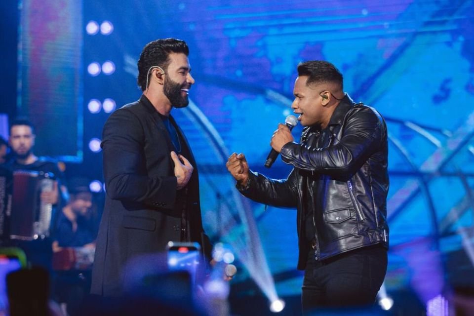 A foto colorida mostra os cantores Gusttavo Lima e Junior Marques