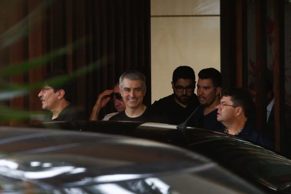 Polícia Federal deixa residência do governador afastado do DF, Ibaneis Rocha, após cerca de 2h30min de buscas. Na imagem, vários agentes saem pela porta da frente - Metrópoles