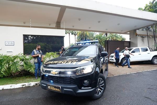 Polícia Federal deixa residência do governador afastado do DF, Ibaneis Rocha, após cerca de 2h30min de buscas. Na imagem, duas viaturas aparecem estacionadas no portão - Metrópoles