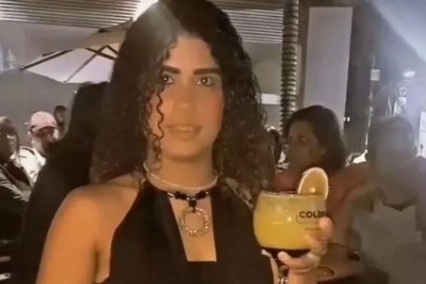 Imagem - mulher segura taça de drink em festa - Metrópoles