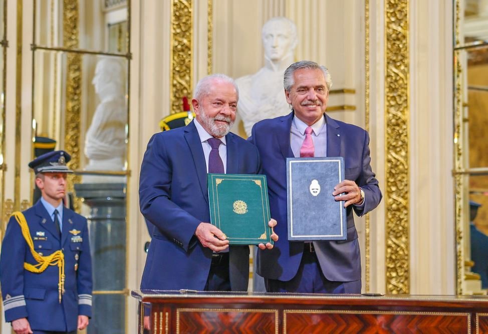 Presidentes Lula e Alberto Fernández, respectivamente do Brasil e Argentina, sorriem e posam com termos de compromissos assinados em salão da Casa Rosada, sede do governo argentino - Metrópoles