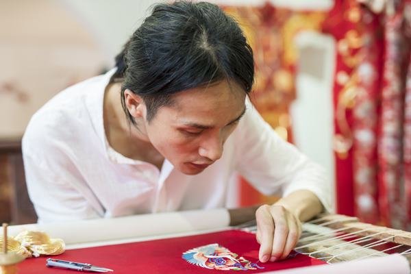Chinês bordando peça em seda - Metrópoles