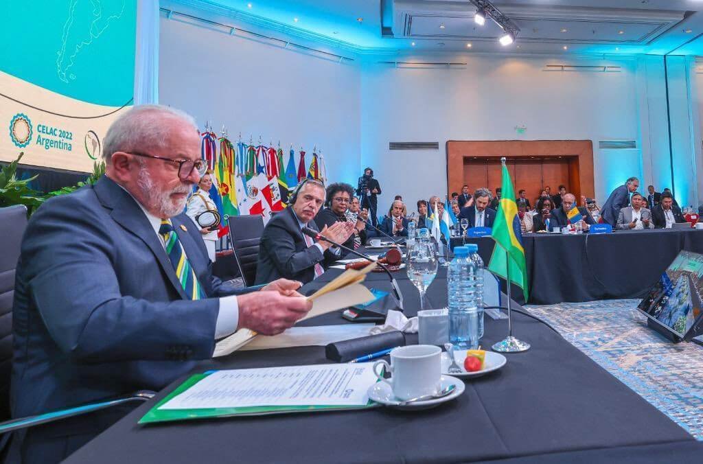 O presidente Lula participa do Celac em Buenos Aires, Argentina, ao lado de outros líderes da América Latina. Vê-se um salão grande, com telões, e diversos convidados cercando a mesa com os participantes - Metrópoles