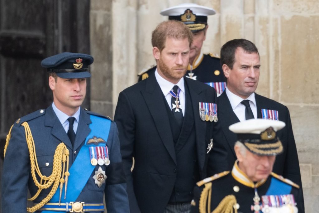 Foto colorida de quatro homens brancos, sendo dois vestidos com trajes militares e os outros dois com terno - Metrópoles