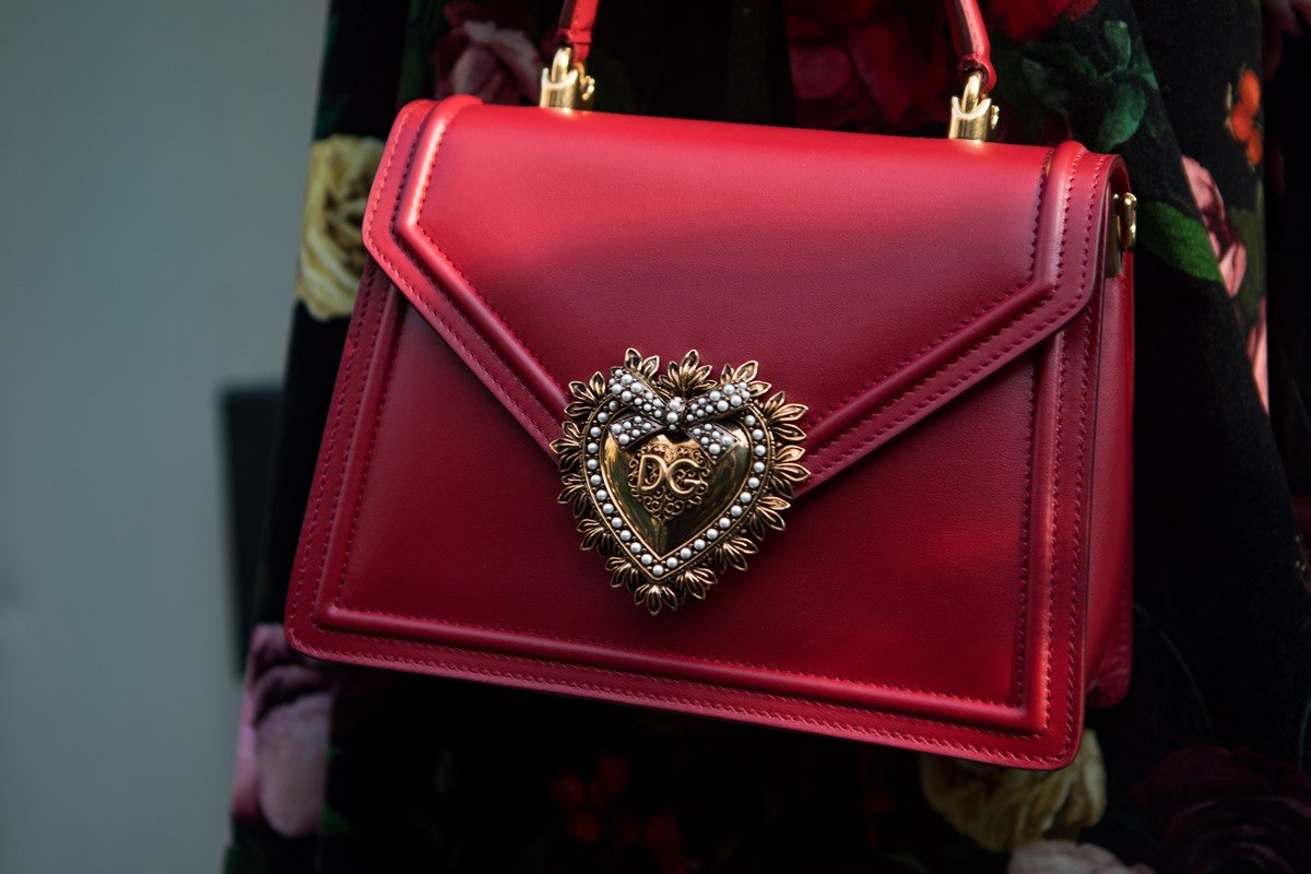 Loyalty bag from Dolce & Gabbana.  The piece is made of red leather and has a gold heart-shaped clasp.  - Metropolises