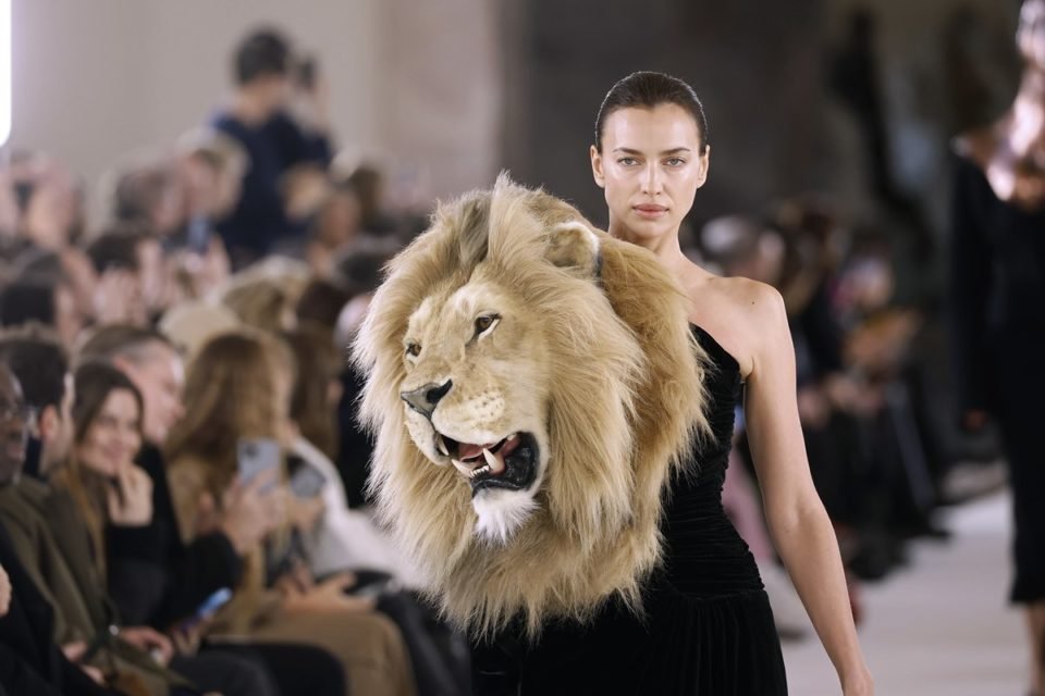Na passarela de alta-costura da Schiaparelli´, a modelo Irina Shayk desfila usando look preto assimétrica com cabeça de leão acoplada - Metrópoles