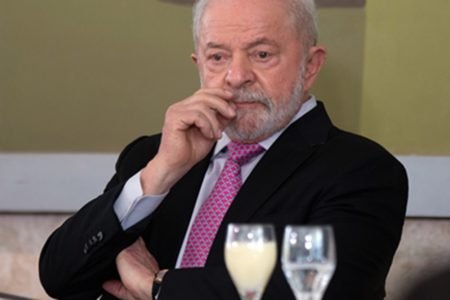 Foto colorida mostra presidente Lula. Ele está com a mão na boca - Metrópoles