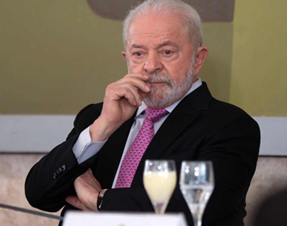 Foto colorida mostra presidente Lula. Ele está com a mão na boca - Metrópoles