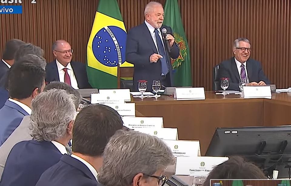 Presidente Lula fala à governadores em encontro no Palácio do Planalto. Ele segura microfone, diante de bandeira do Brasil - Metrópoles