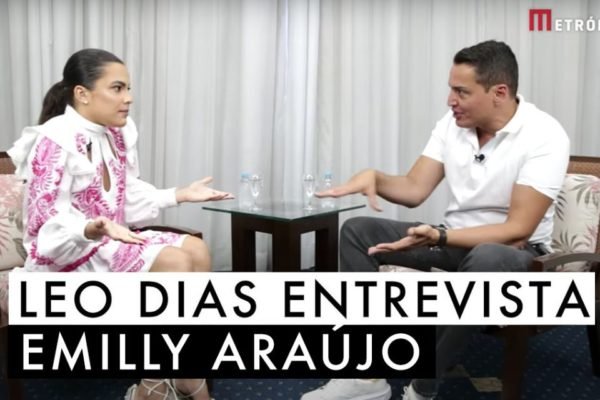 Emilly Araújo e LeoDias sentados um de frente para o outro em cadeiras, conversando em uma entrevista